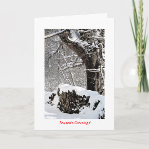 Tarjeta Festiva Nieve en la pila de madera