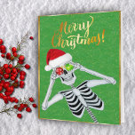 Tarjeta Festiva Ornamentos de esqueleto sonriente lindo Santa Hat<br><div class="desc">Esta tarjeta de saludo de los Navidades tiene un lindo esqueleto sosteniendo dos brillantes adornos navideños con copos de nieve hasta los ojos con un sombrero de Santa roja sobre un fondo verde con finas chispas de oro y un marco dorado. Personalizar el versículo interior más su nombre con las...</div>