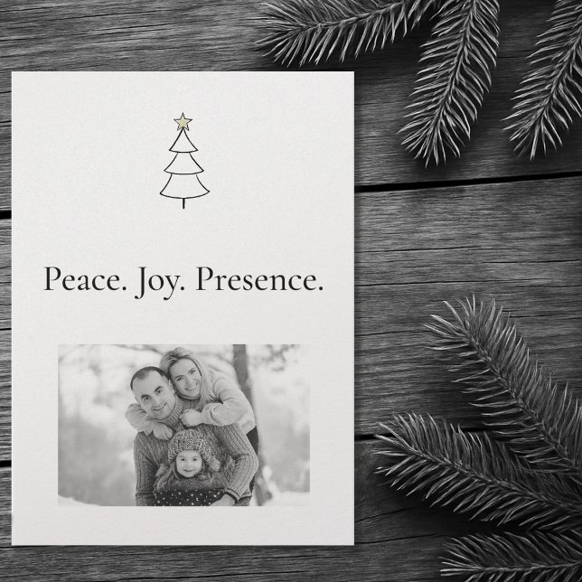Tarjeta Festiva Paz. Alegría. Presencia. Navidades de fotografía m (Front of the Christmas card on a wooden table with Christmas pine tree branches.)