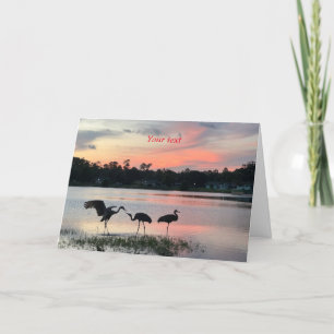 Tarjeta Festiva Silueta de grúas de arena al atardecer en el lago