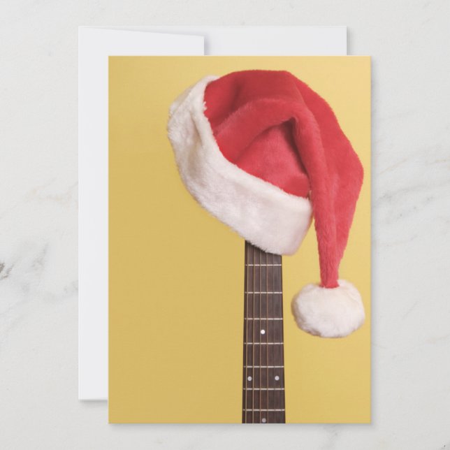 Tarjeta Festiva Un gorra de Santa cuelga en una guitarra acústica (Anverso)