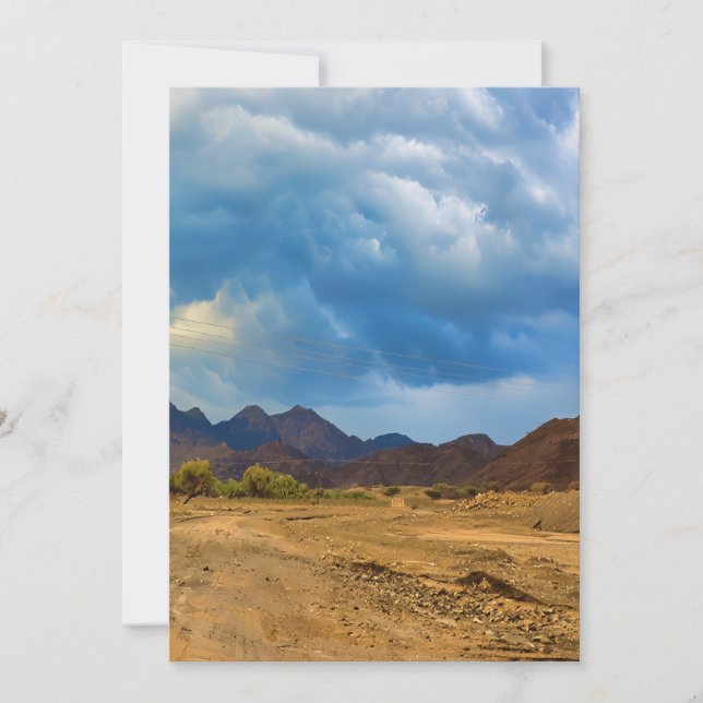 Tarjeta Festiva Un paisaje árido bajo un cielo dramático y nublado (Anverso)