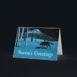 Tarjeta Festiva Winter Wolf - Saludos de temporada<br><div class="desc">Un lobo camina sobre una nieve dura en la noche; un pico cubierto de árboles en el fondo. La luz de la luna refleja la nieve y la ladera pálida de los abedules. Los ojos del lobo también brillan con la luz de la luna reflejada. El texto que dice "Saludos...</div>