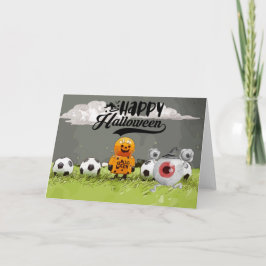 Tarjeta Fútbol Feliz Halloween con bolas sobre hierba verd