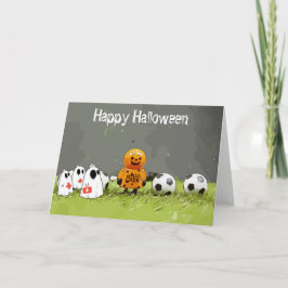 Tarjeta Fútbol Feliz Halloween con bolas sobre hierba verd