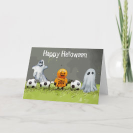 Tarjeta Fútbol Feliz Halloween con bolas sobre hierba verd