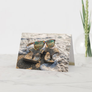 Tarjeta Gafas de sol y sandalias en la rompiente del océan