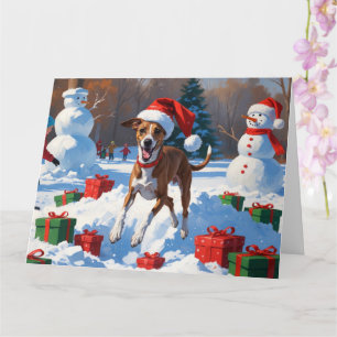 Tarjeta Galgo corriendo en la nieve con sombrero de Navida