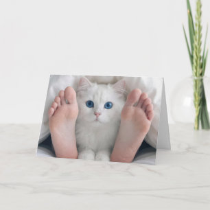 Tarjeta Gato de cumpleaños y pies humanos bajo una edredón