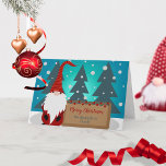 Tarjeta Gnome en medio de un nevado Navidad invernal<br><div class="desc">Disfrute de la alegría de la temporada de vacaciones con esta encantadora y caprichosa tarjeta de bienvenida de Navidades. La carta, con un tranquilo telón de fondo azul, cuenta con un delicioso gnomo adornado con un gorra de rayas rojas y naranjas y una barba blanca ondulada que le aporta un...</div>