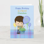 Tarjeta Grandson Special Happy Birday Boy con pastel<br><div class="desc">Una tarjeta dulce para un nieto especial, con un fondo azul con una manta azul baja y un niño dulce con una camisa azul y amarilla y jeans. Hay un quequito verde delante del niño y globos flotando alrededor. Diseño original de Cheryl Seslar en Digital Craft Supplied, Globos de diseño...</div>