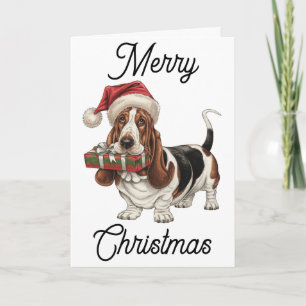 Tarjeta Hound basset en Santa hat presente en la boca