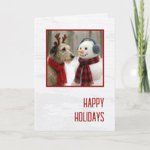 Tarjeta Lobo Irlandés de Navidad mirando a un adorable muñ