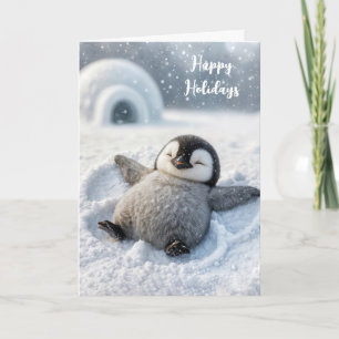 Tarjeta Navidades de pingüino haciendo un ángel de nieve