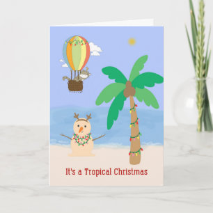 Tarjeta Navidades en la palmera tropical y muñeco de arena