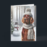 Tarjeta Navidades irlandeses sentados con hombre de nieve<br><div class="desc">Un perro con un gorra de punto gris y una bufanda parados en un bosque de nieve al lado de un muñeco de nieve para Navidades</div>