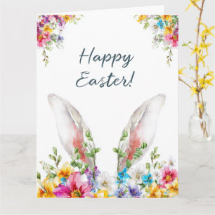 Tarjeta orejas de conejo de pascua asomando entre flores