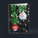 Tarjeta Ornamentos navideños de Snowman con guirnaldas<br><div class="desc">Ornamentos de Navidad rojos y blancos con hombres de nieve colgando de la guirnalda verde sobre un fondo luminoso de color negro</div>