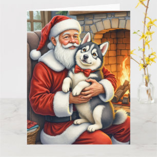 Tarjeta Papá Noel sosteniendo arte navideño de Alaskan Mal