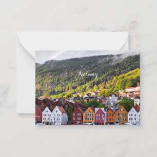 Tarjeta Pequeña Pueblo noruego con montañas en segundo plano