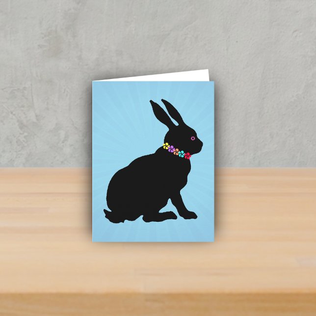 Tarjeta Perfil lateral sentada Flores de conejo negro Ojo  (Black silhouette sitting rabbit wearing colourful flowers on Spring or Easter blue note card.)
