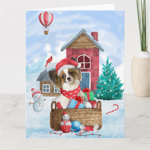 Tarjeta Perro Papillon en casa de Navidad con nieve