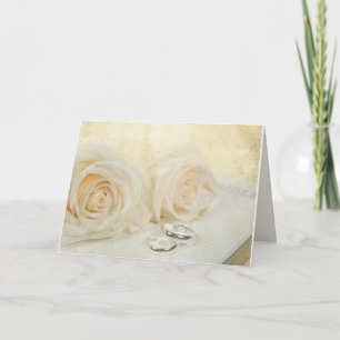 Tarjeta rosas y anillos bodas sobre la Biblia