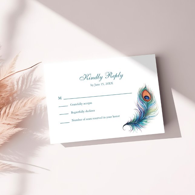 Tarjeta RSVP de boda verde azulada de pluma de pav (Teal Peacock Feather Wedding RSVP Card on a white table.)
