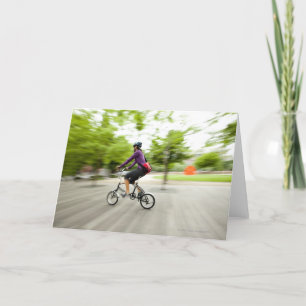Tarjeta Una mujer que usa una bici plegable para conmutar