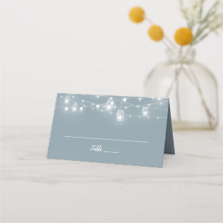 Tarjetas de lugar de boda dobladas con luces de cu