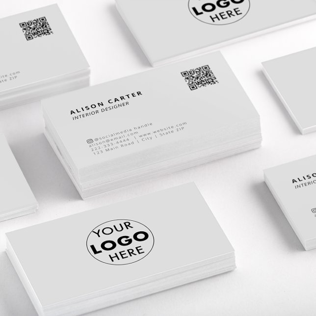 Tarjetas de visita de negocios modernas y grises | (Stacks of off white business cards showing the front of the card with QR code and logo at the back.)