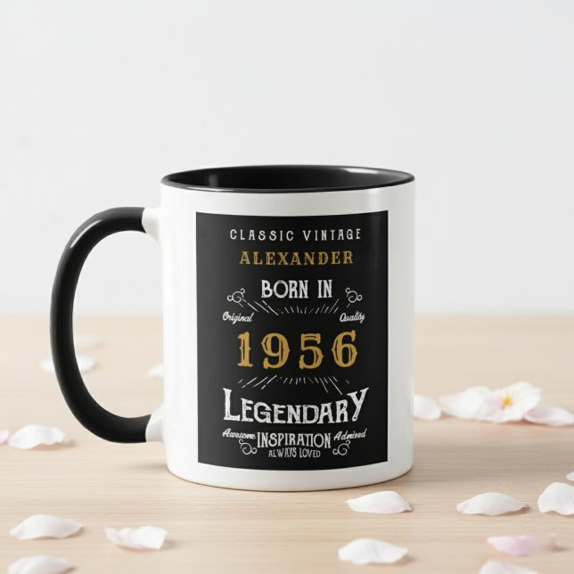 Taza 70th Birthday 1956 Legend Retro Black Personalized (Born 1956 birthday gift mug. White wall background, wood table with petals.)