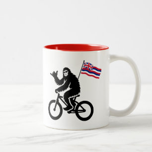 Taza Bicolor Bigfoot en bicicleta con bandera de Hawái