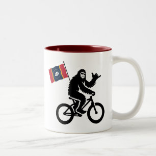 Taza Bicolor Bigfoot en bicicleta con la bandera de Mississippi
