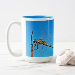 Taza Bicolor Colgar Sobre La Dragonfly Artística Contra El Azul