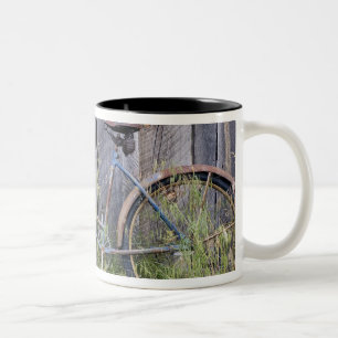 Taza Bicolor EE.UU., Oregón, Bend. Una bicicleta vieja y ruinos