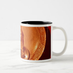 Taza Bicolor Pectoral con un rostro humano