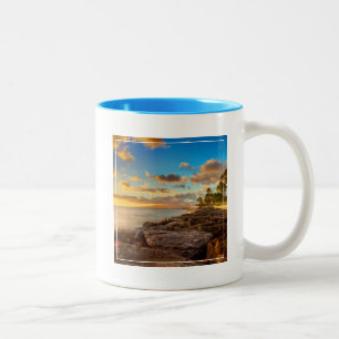 Taza Bicolor Puesta del sol del océano sobre las rocas y la