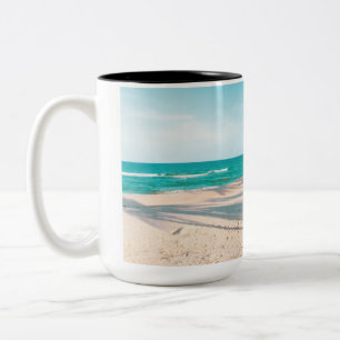 Taza Bicolor Surf board en la playa tirando almohada