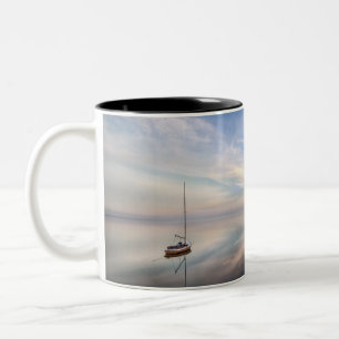 Taza Bicolor Un velero solitario en las aguas tranquilas de
