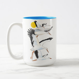 Taza Bicolor Una bandada de cigüeñas blancas que vuelan sobre l