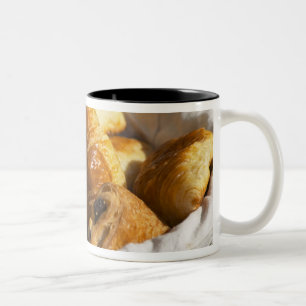 Taza Bicolor Una cesta de mimbre para el desayuno con croissant