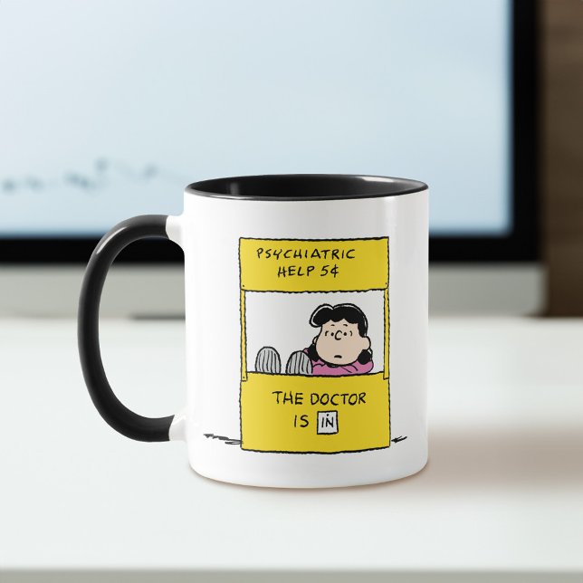 Taza Cacahuetes | Lucy y el Médica están (Mug on desk)