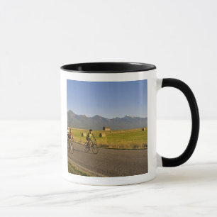 Taza Ciclistas de carretera circulan por un camino rura