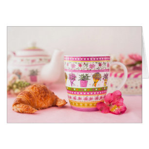 Taza con té, el Croissant y la flor