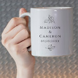 Taza De Café Blanco Negro Elegante De La Boda Deja Los Nombres<br><div class="desc">Elegante diseño de tazas de café boda en blanco y negro que incluye los nombres de la pareja y la fecha del evento en un hermoso y clásico tipo de letra serif en negro sofisticado sobre un fondo blanco y fresco. La composición tradicional fresca está embellecida con hojas botánicas decorativas....</div>