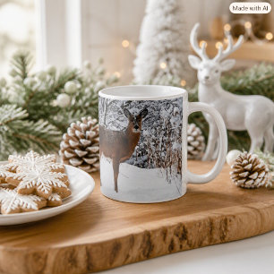 Taza de café con ciervo de cola blanca en nieve in