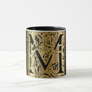 Taza de café con letra M decorativa en negro y dor