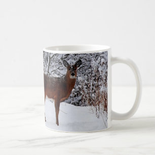 Taza de café con venado de cola blanca en nieve in