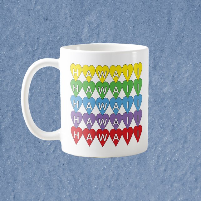 Taza De Café Corazones del arco iris de Hawái (A mug with a rainbow heart pattern that spells Hawaii.)